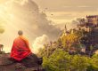 Person meditating on hill with scenic background