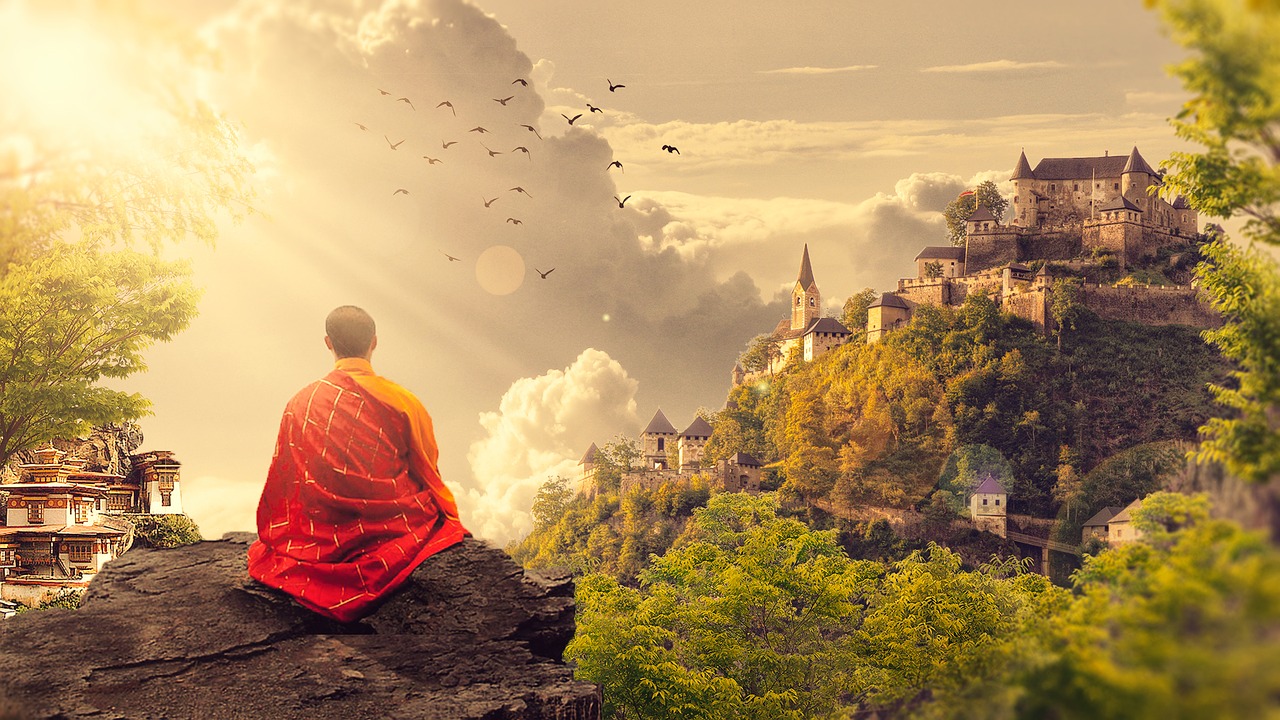 Person meditating on hill with scenic background